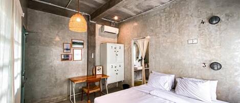 A bedroom with a bed, a desk, and a wardrobe.