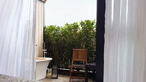 A bathroom with a toilet, a sink, and a chair. There is a wooden fence and greenery in the background. - Stunning Matakana Retreat! (Matakana)