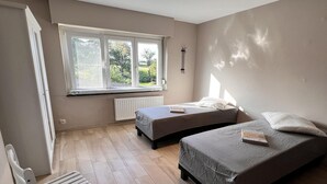 A bedroom with two beds, a window, a radiator, and a bench. - Beautiful House With 4 Bedrooms in Hees (Bilzen)