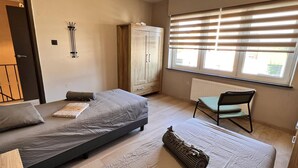 A bedroom with two beds, a wardrobe, a chair, and a radiator. - Beautiful House With 4 Bedrooms in Hees (Bilzen)