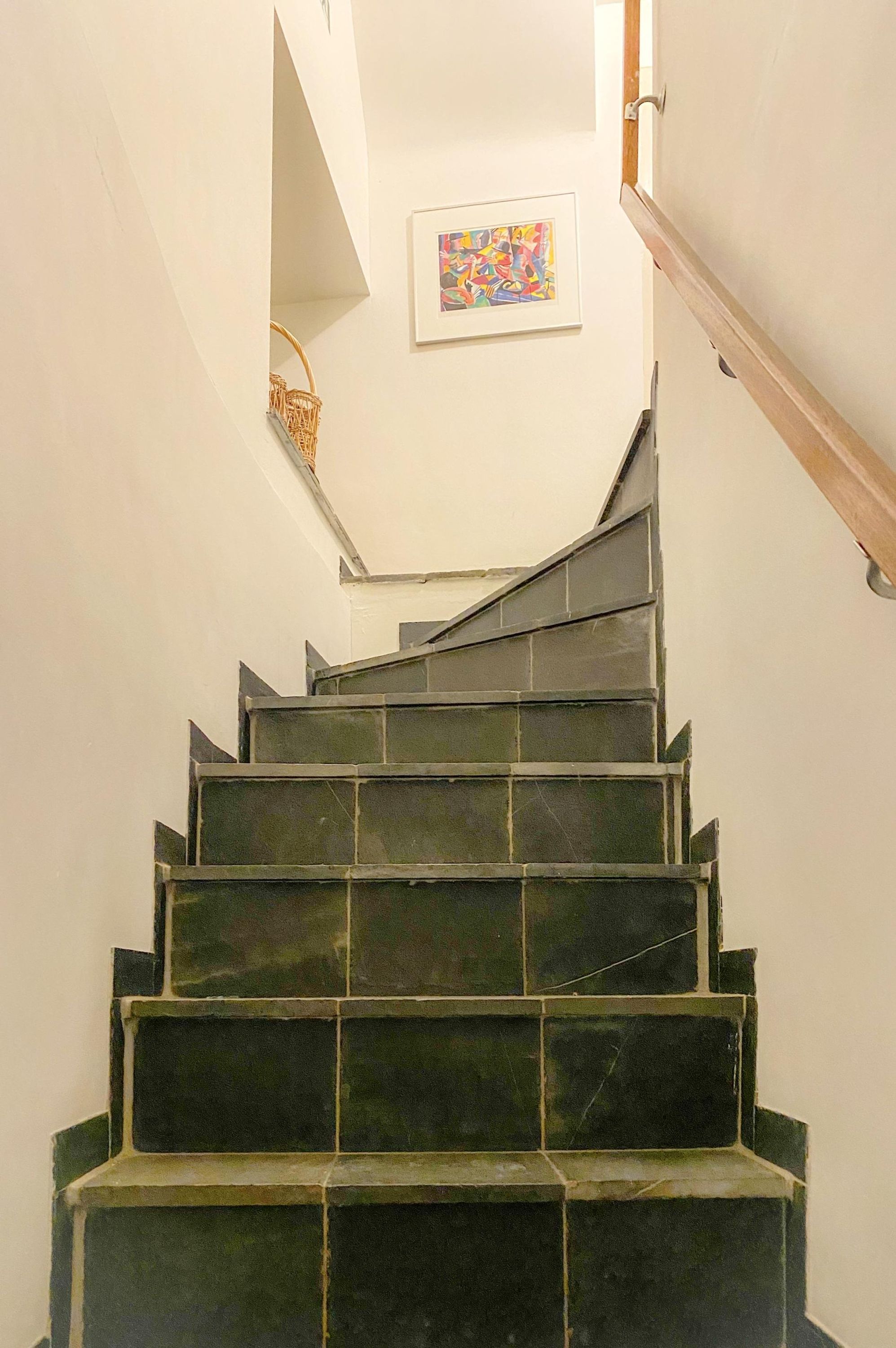 Una escalera con baldosas oscuras que lleva a una plataforma.