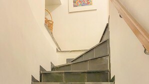 A staircase with dark tiles leading to a landing.