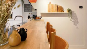 A modern kitchen with wooden cabinets, a black vase, and a wooden table. - Charming Retreat in the Heart of Oud-beijerland (Oud-Beijerland)