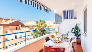 Un balcón con mesa dispuesta para el desayuno, con vista a la ciudad.
