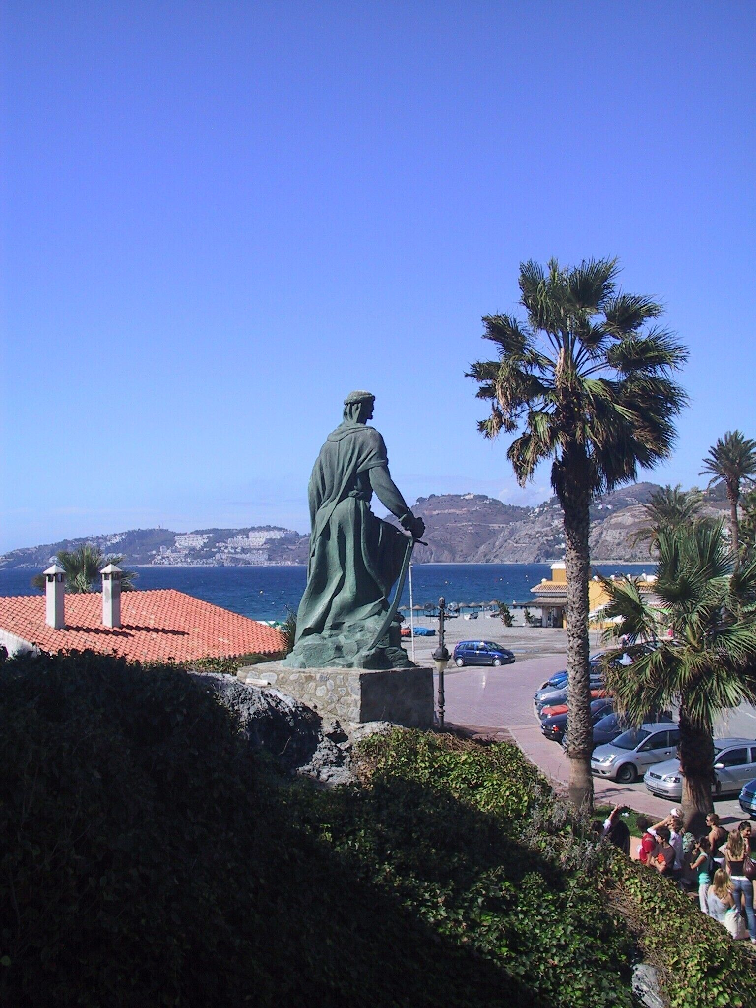 A statue overlooking a coastal area with a clear sky.