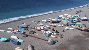 Une plage où l’on peut voir de nombreux bateaux et quelques personnes.