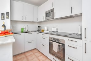 A modern kitchen with white cabinets, a built-in microwave, a coffee maker, and a toaster. - Villa "Estrella" with Sea Views, in the Countryside with Private Pool and For Families (Almuñécar)