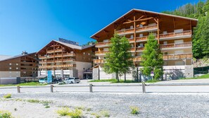 A hotel with multiple balconies, a ski lift, and a clear sky.