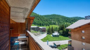A wooden building with a balcony overlooking a mountainous area with a hotel sign. - Apartment for 6 people with mountain views, a swimming pool and parking (Allos)