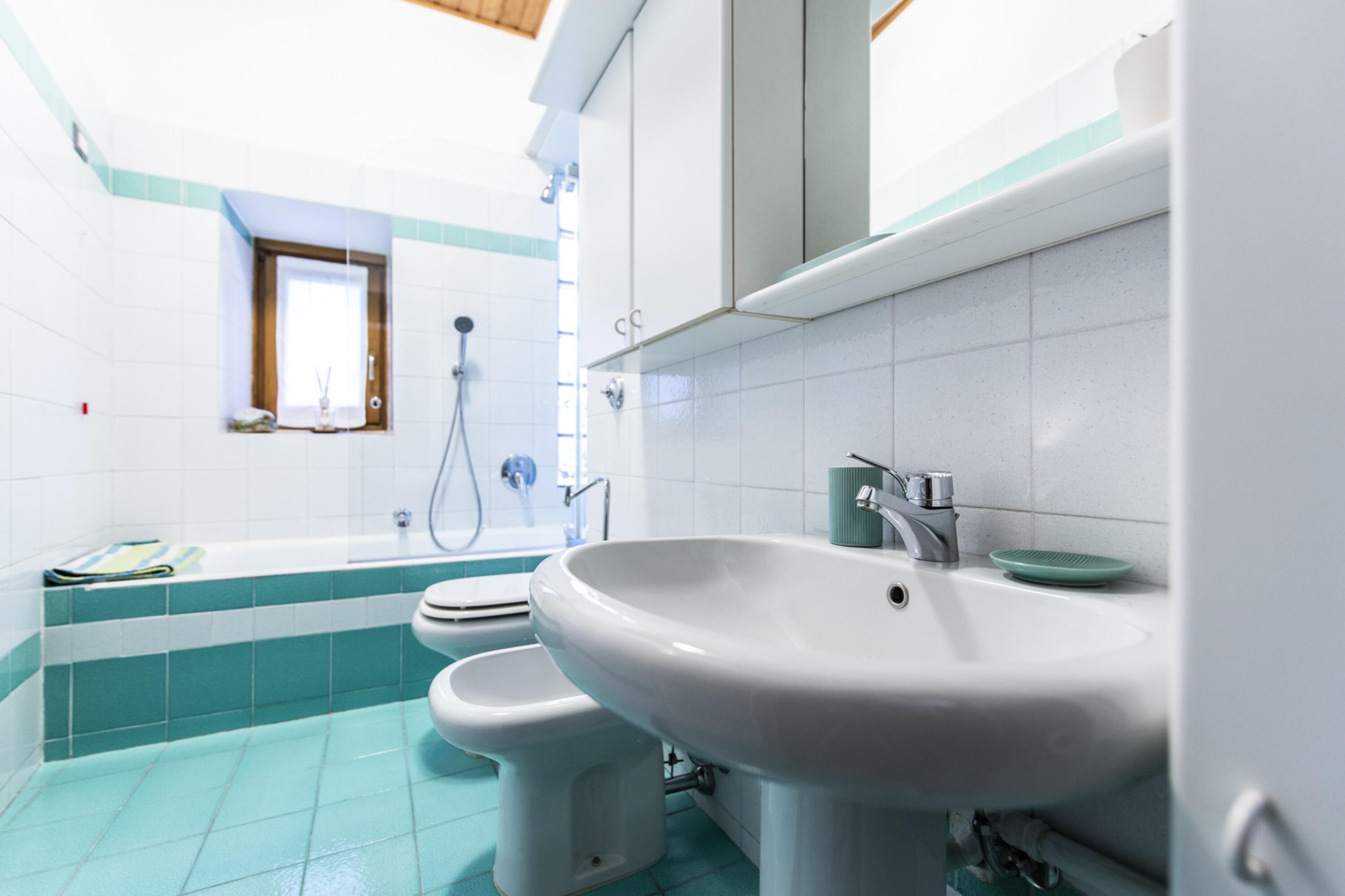 A bathroom with a bathtub, toilet, and sink.
