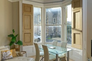 A room with a bay window, a glass table, and a sofa. - Gorgeous Apartment Seconds from Seafront, Clevedon (Clevedon)