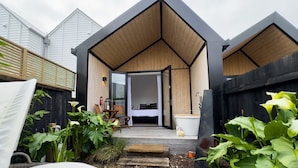 A modern house with a wooden exterior and a small porch area. - Gorgeous & Relaxing in Matakana (Matakana)