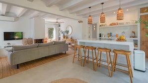 A modern kitchen with white cabinetry, a central island with stools, and pendant lighting. - Los Jazmines - Javea, Costa Blanca (Javea)