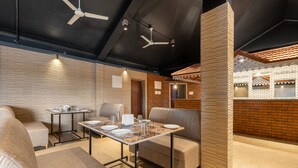 Un comedor moderno con techo alto, paredes de ladrillo visto y mobiliario contemporáneo.