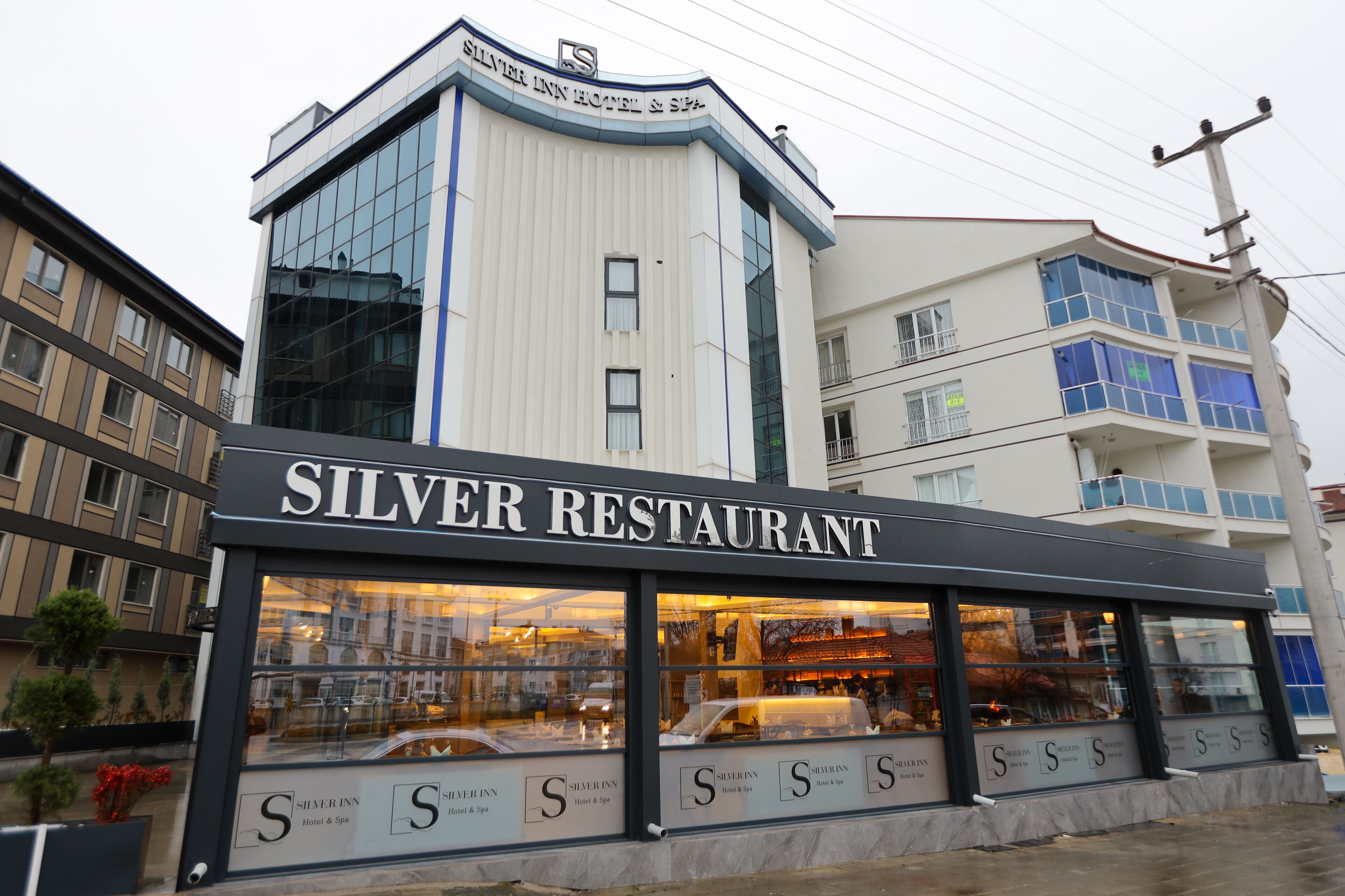 A Silver Inn Hotel & Spa with a modern glass facade and a prominent signage.