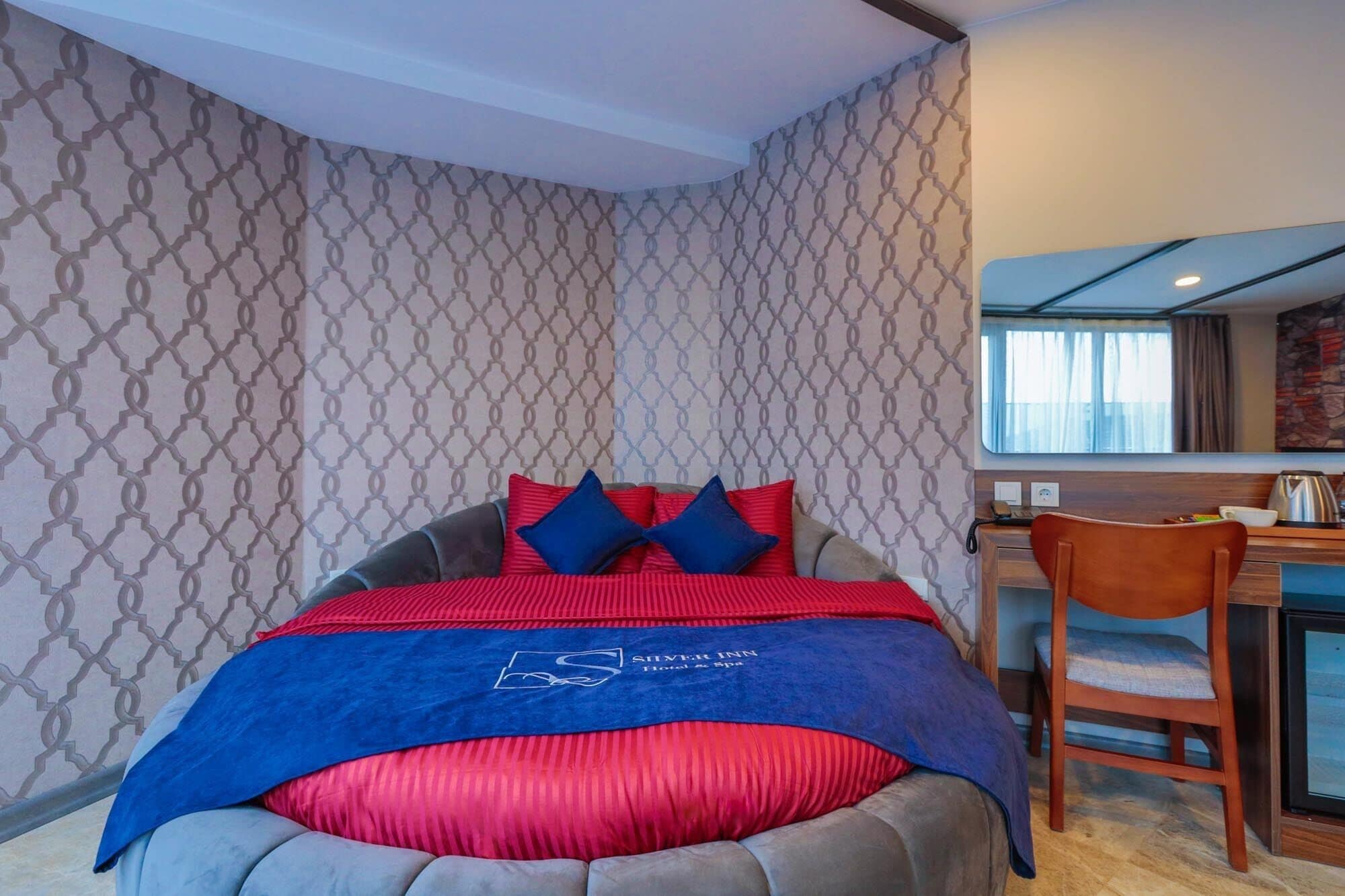 Una habitación de hotel con cama, escritorio y silla.