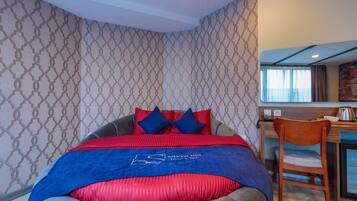 Una habitación de hotel con cama, escritorio y silla.