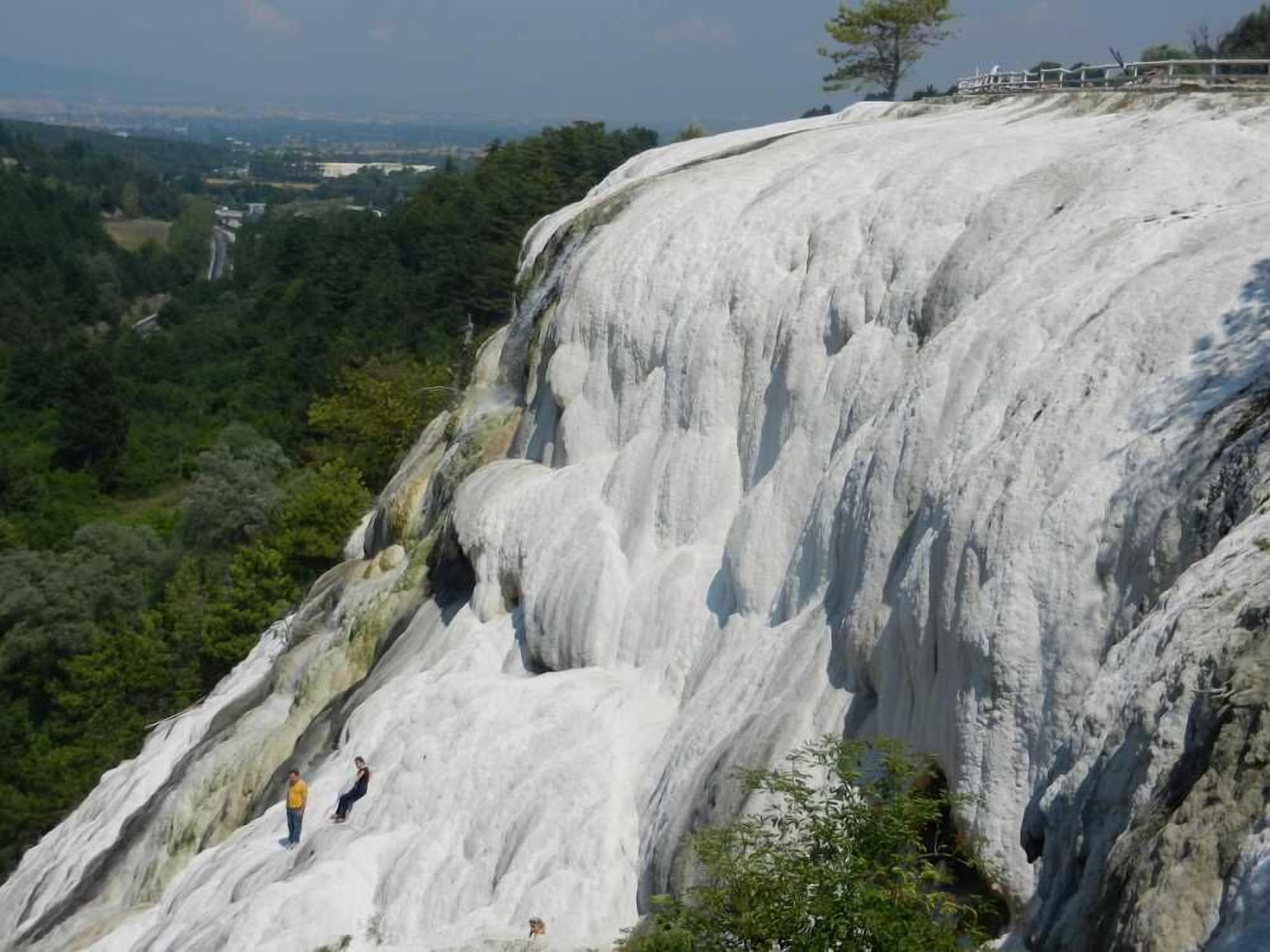 A large, rugged cliff with a waterfall.