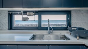 A modern kitchen with a built-in window overlooking a beach. - KOKO Premier Resort (Seogwipo)