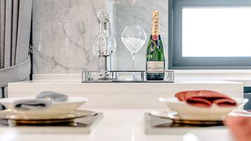 Uma mesa de jantar posta com pratos, um copo de água, uma garrafa de champanhe Moët & Chandon e um jarro para vinho.