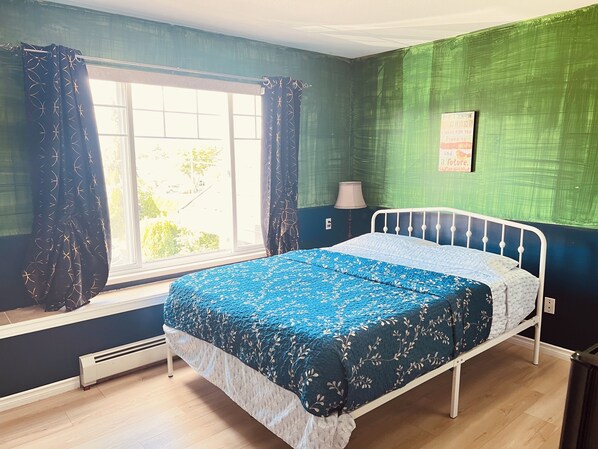A bedroom with a bed, a window with curtains, a radiator, and a wall with a poster. - RVH'S/Rm A
Good location, 45minutes fromYVR Airport (Surrey)