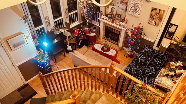 A multi-level living space with a staircase, a fireplace, and a Christmas tree.