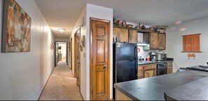 A kitchen with wooden cabinets, a black refrigerator, and a countertop.