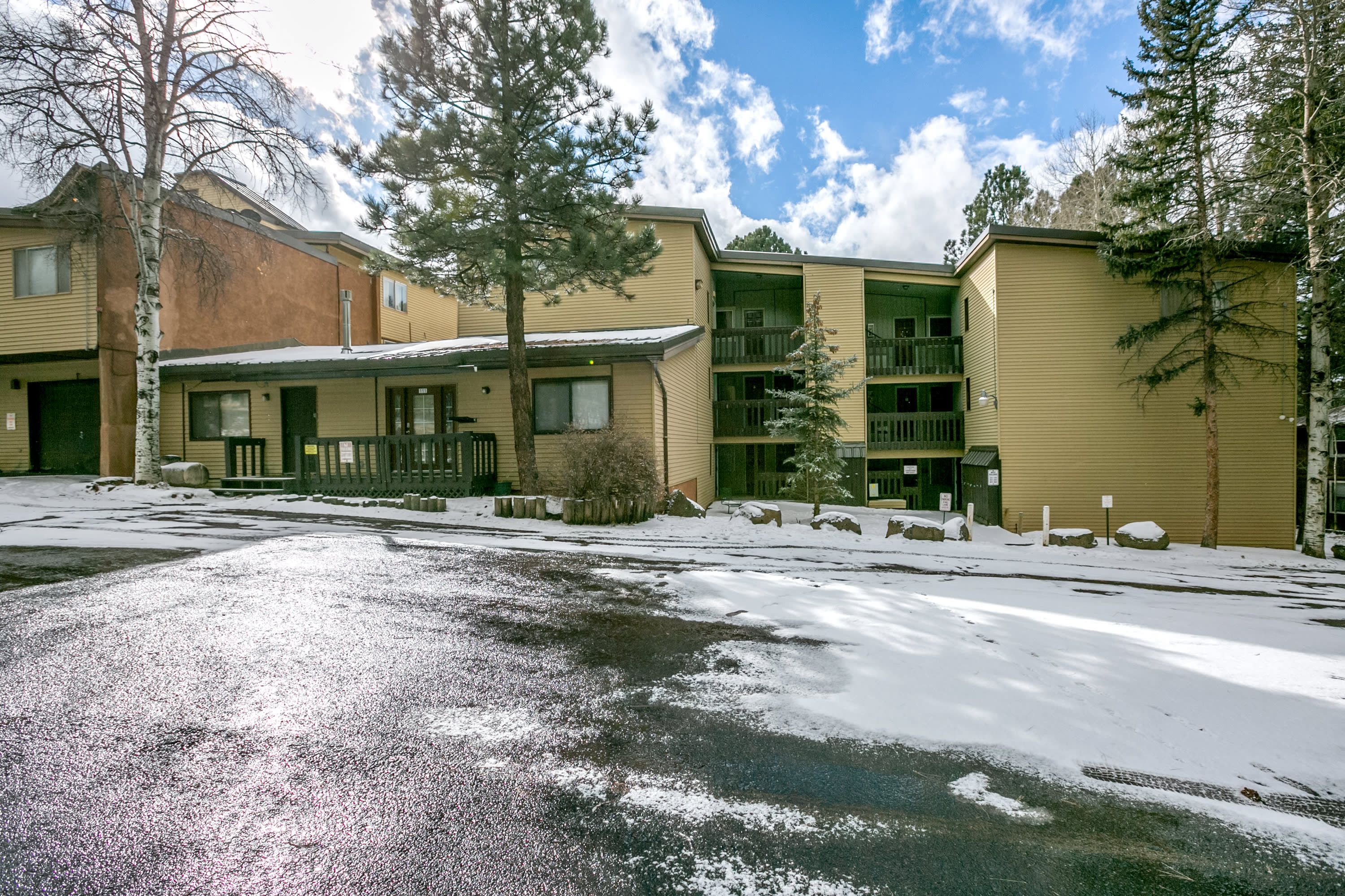 A multi-story building with a covered entrance and a snow-covered ground.