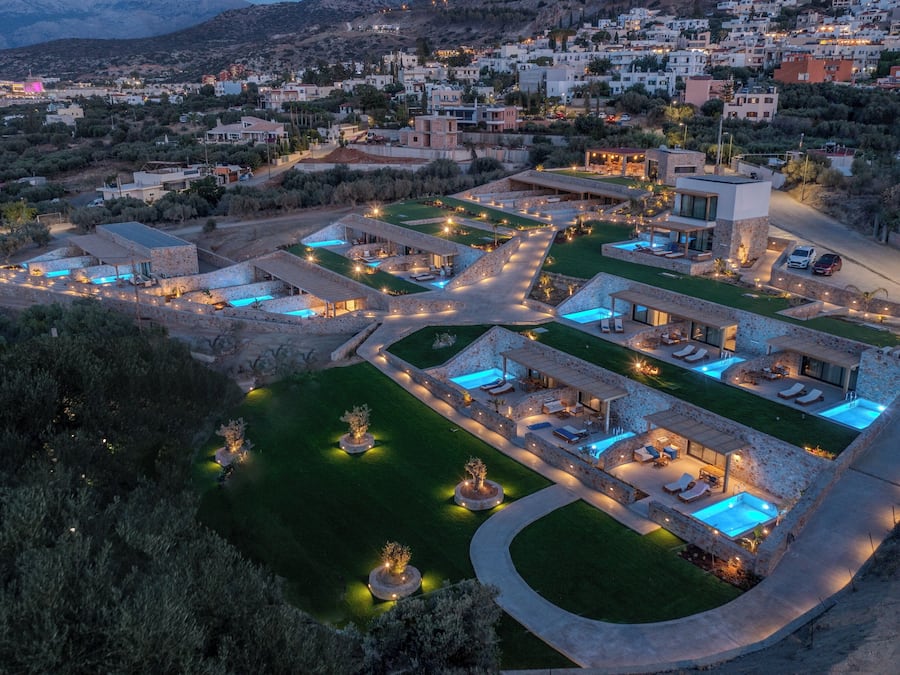 A luxurious resort with multiple swimming pools, outdoor seating areas, and a well-maintained landscape.