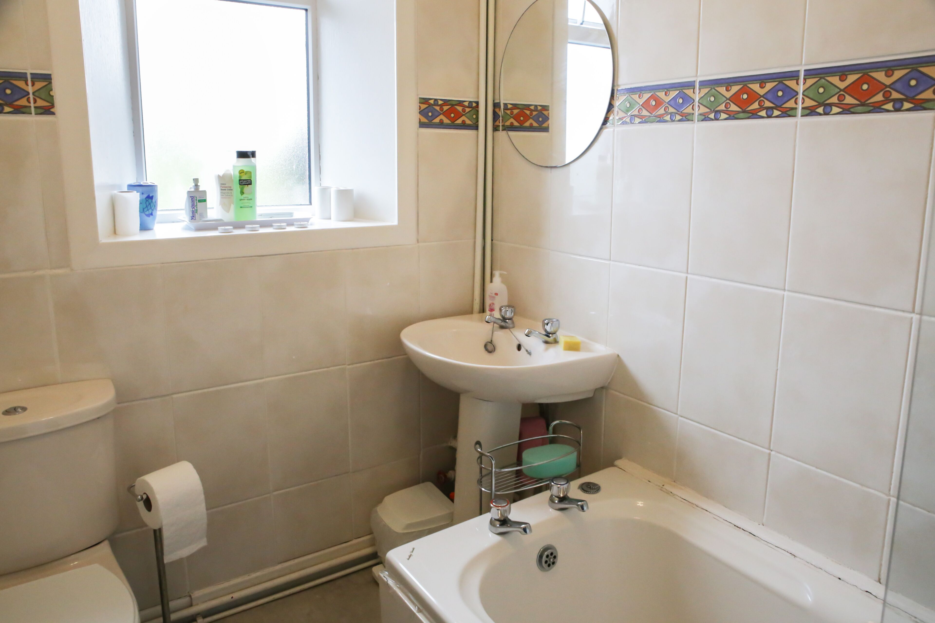 Une salle de bain avec des toilettes, un lavabo et une baignoire.