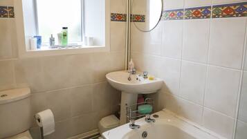 Une salle de bain avec des toilettes, un lavabo et une baignoire.