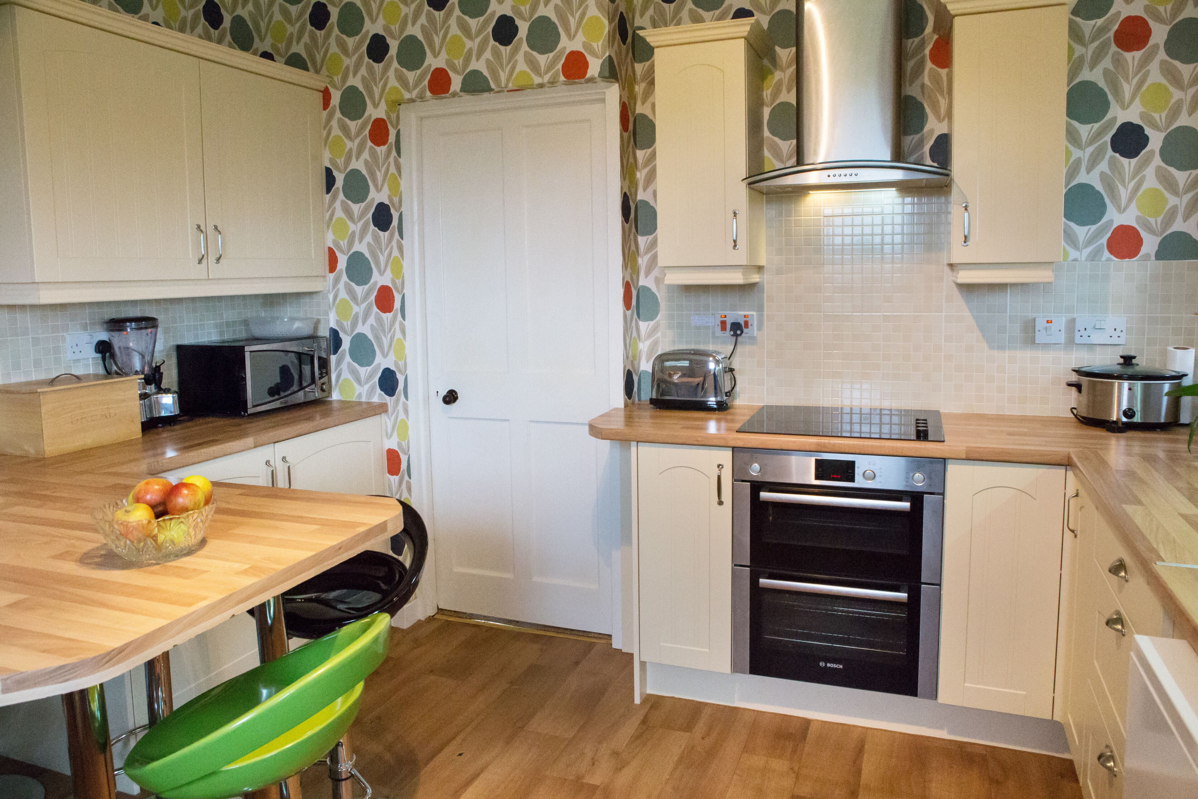 A kitchen with white cabinets, a Bosch oven, and a microwave.