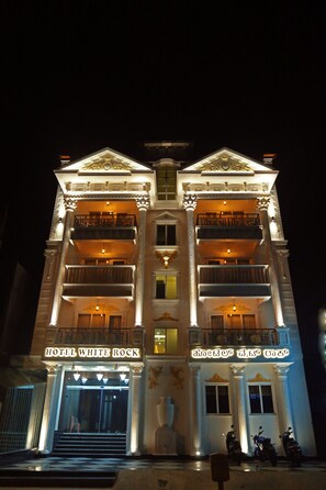 A multi-story hotel with balconies and a grand entrance.