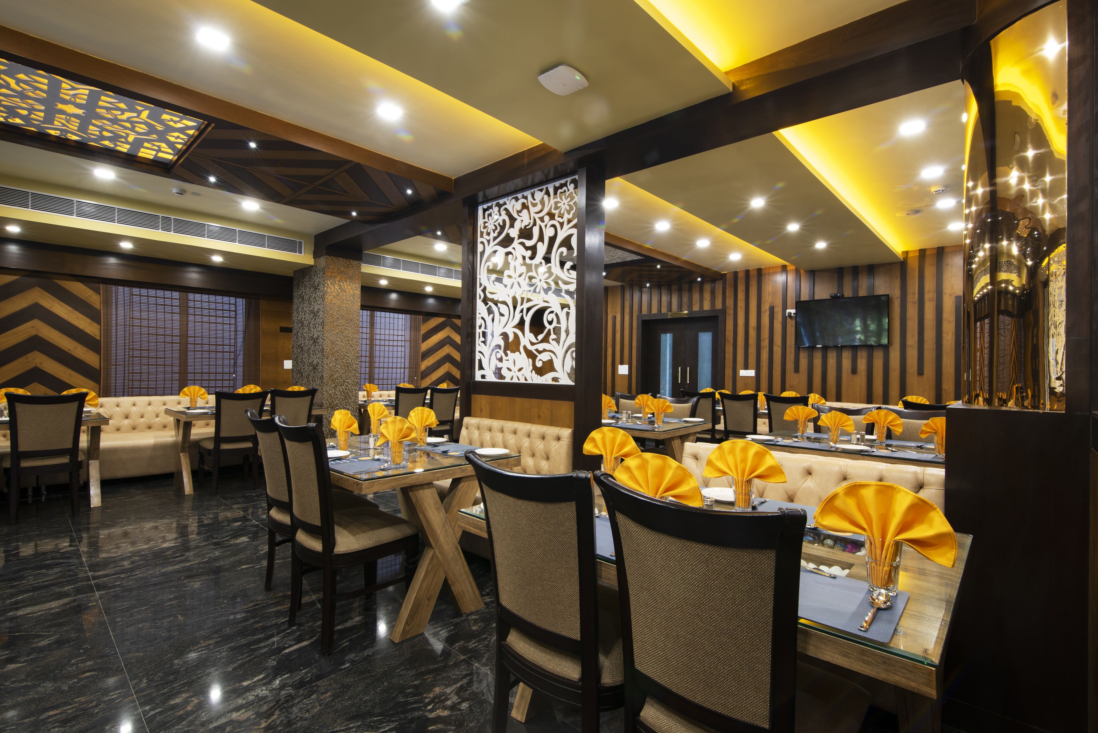 Un restaurante con una decoración moderna, que ofrece una variedad de opciones de asientos, incluyendo cabinas y mesas, y un panel decorativo en la pared.