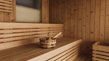 A wooden sauna with benches and a wooden bucket with a ladle.