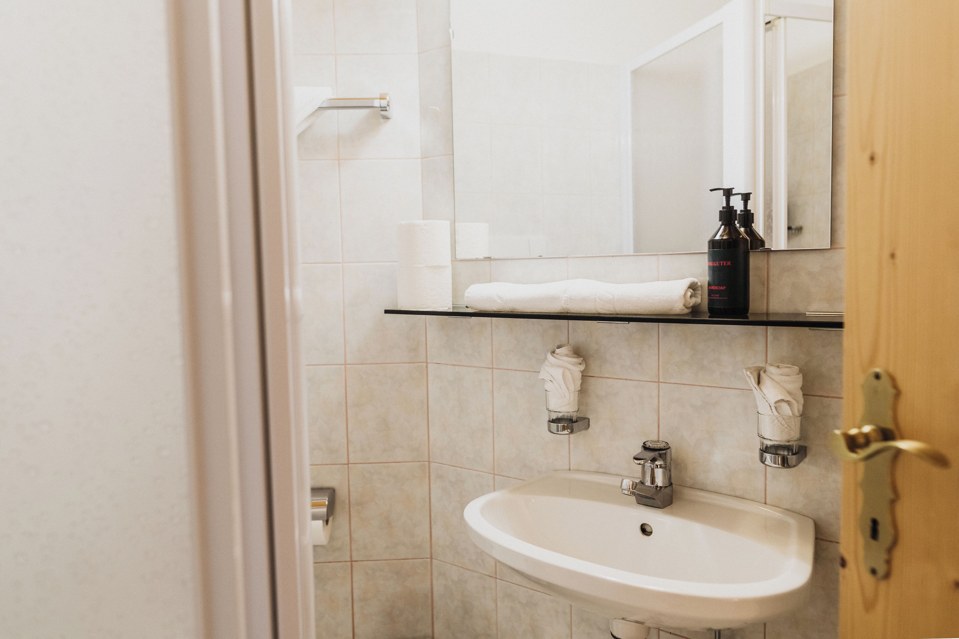 Ein Badezimmer mit Waschbecken, Spiegel und Handtuchhalter.