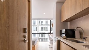 Une cuisine moderne avec des meubles en bois, un four à micro-ondes encastré et un évier.