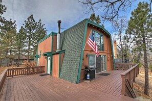 A wooden cabin with a deck, an American flag, and a chimney. - Tree Top Villa By Destination Big Bear:Upper Moonridge! Decks! Pool/Ping Pong Table! Foosball! (Big Bear City)