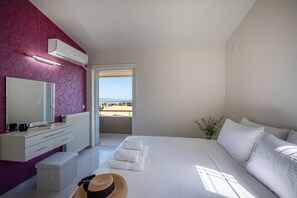 Een slaapkamer met een bed, nachtkastje, spiegel en uitzicht.