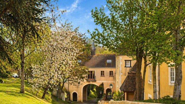 Un bâtiment historique doté d’une arche centrale, d’un mur en pierre et d’une allée pavée.