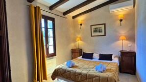 A hotel room with a bed, two bedside tables, a window with curtains, and wall-mounted lamps. - Petite Bergerie Avec Piscine Privée & Climatisation (San-Gavino-Di-Carbini)