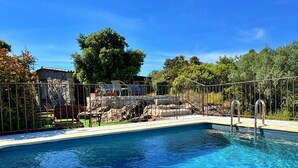A clear blue pool with a stone structure and lounge chairs in the background. - Petite Bergerie Avec Piscine Privée & Climatisation (San-Gavino-Di-Carbini)