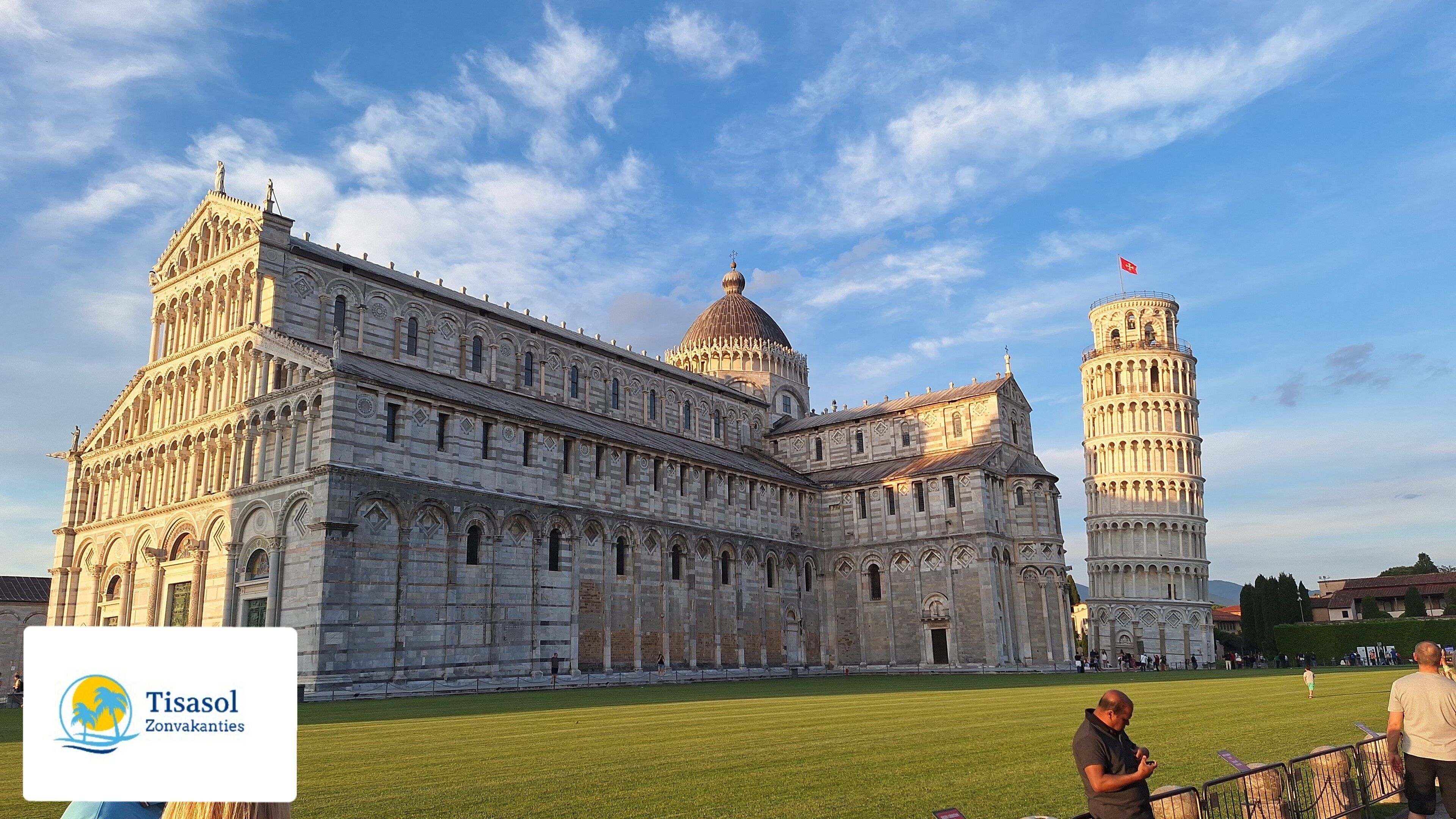 Ein großes, historisches Gebäude mit einem markanten Turm und einer Kuppel, umgeben von einer Rasenfläche.
