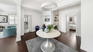 Un interior moderno con una mesa de comedor redonda, una silla azul y una lámpara colgante blanca.