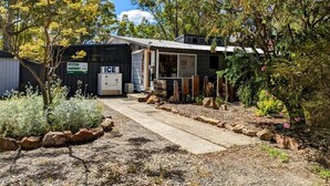 A rustic building with a concrete pathway leading to a wooden door labeled "ICE." - The Summit View by Tiny Away (Dadswells Bridge)