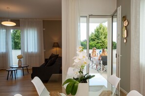Un salon moderne avec un canapé, une table à manger et une orchidée en pot.