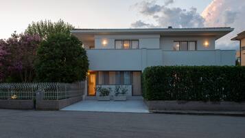 Stylish two-story residence with a flat roof, large windows, and a prominent entrance.