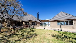 A two-story house with a stone exterior and a chimney. - Shekinah Lion and Game Lodge  (Vaalwater)