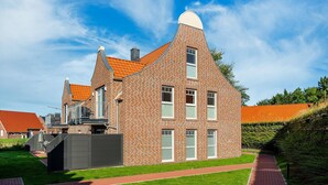 A modern brick building with a unique curved roof and multiple windows.