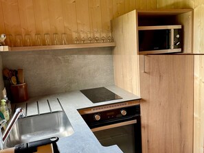 A compact kitchen with a built-in microwave, a stove, and a sink.